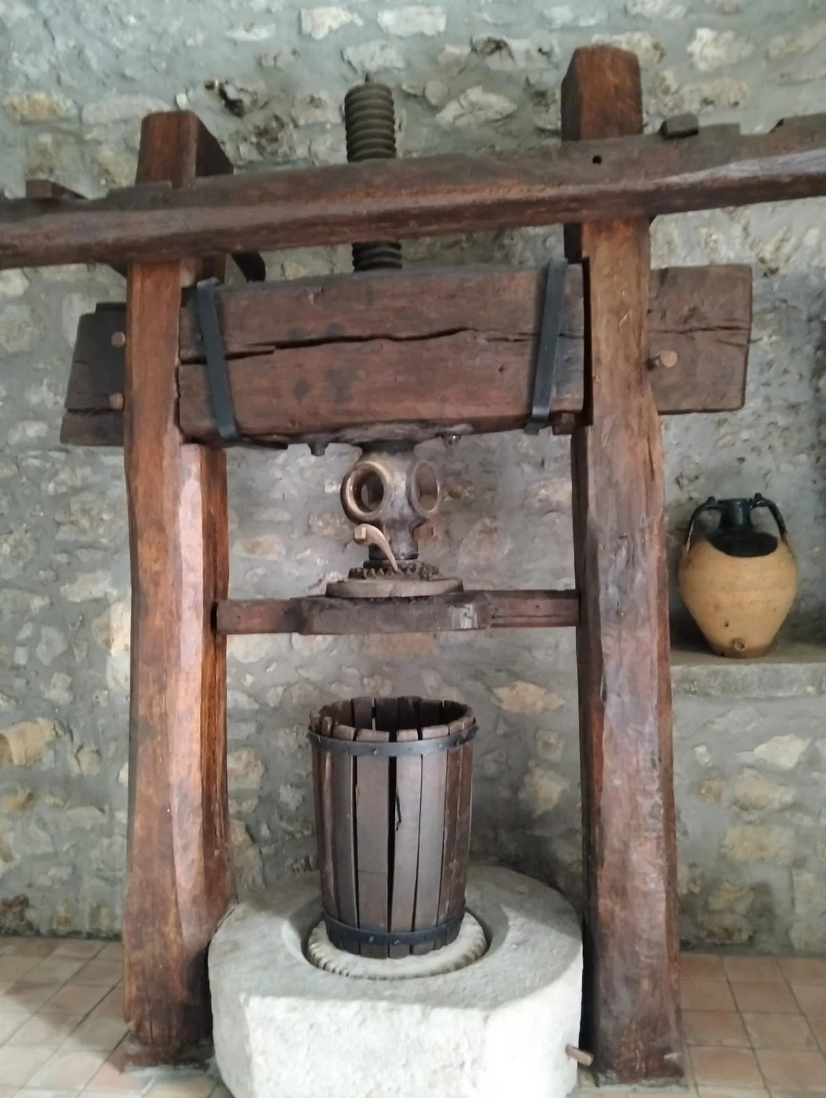 Torchio storico con vite e trave di legno per la spremitura della pasta di olive